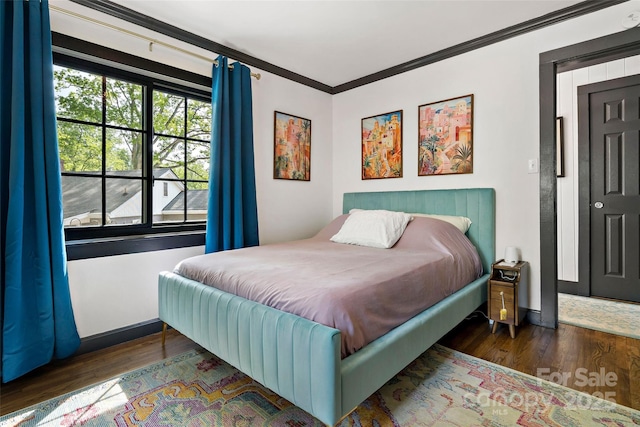 bedroom featuring ornamental molding and wood finished floors