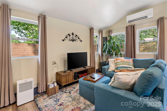 living room with a wall mounted AC, wood finished floors, and lofted ceiling
