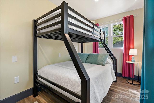 bedroom with baseboards and wood finished floors