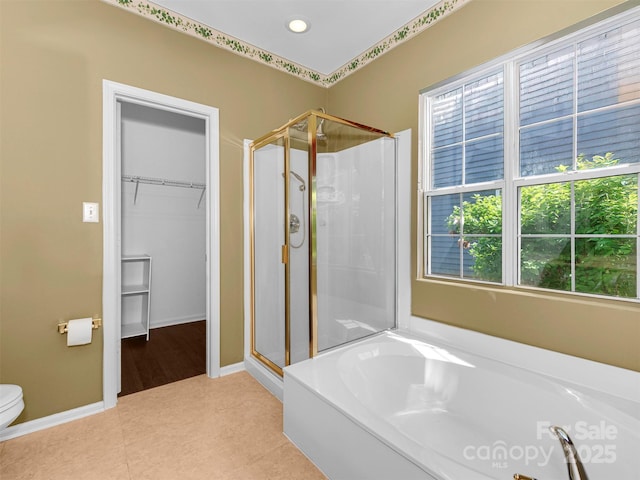 2825 Redfield Dr, Charlotte, NC 28270 - full bathroom featuring a stall shower, a bath, a walk in closet, toilet, and tile patterned flooring