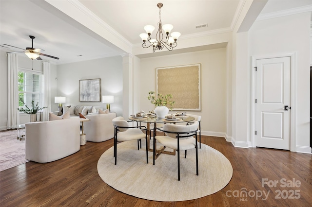 dining space featuring crown molding, dark wood-style floors, a chandelier, baseboards, and ceiling fan