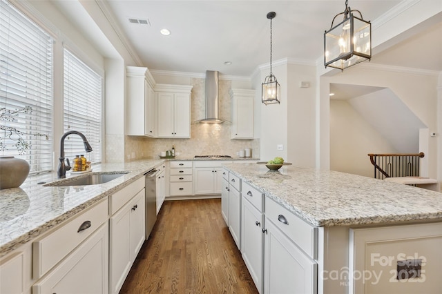 kitchen featuring wall chimney range hood, a sink, a center island, wood finished floors, and backsplash