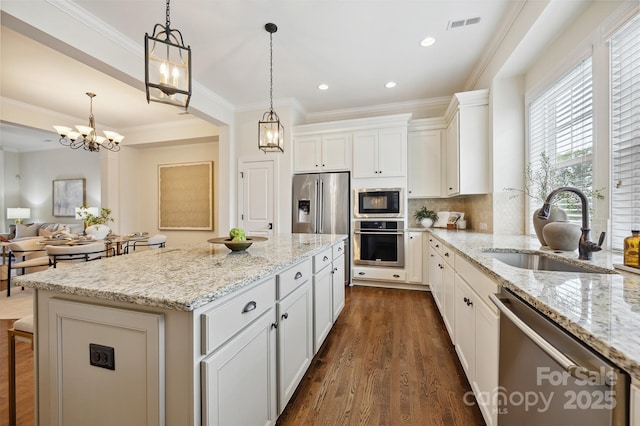 kitchen featuring stainless steel appliances, a sink, dark wood finished floors, white cabinets, and a chandelier