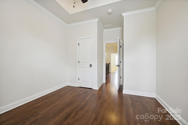 unfurnished room with dark wood-type flooring, baseboards, a smoke detector, crown molding, and a ceiling fan