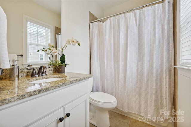 bathroom with tile patterned floors, toilet, plenty of natural light, and vanity
