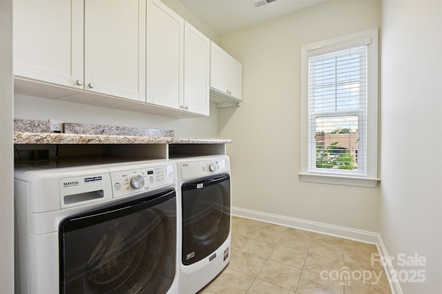 laundry room with washer and clothes dryer, cabinet space, baseboards, and light tile patterned floors
