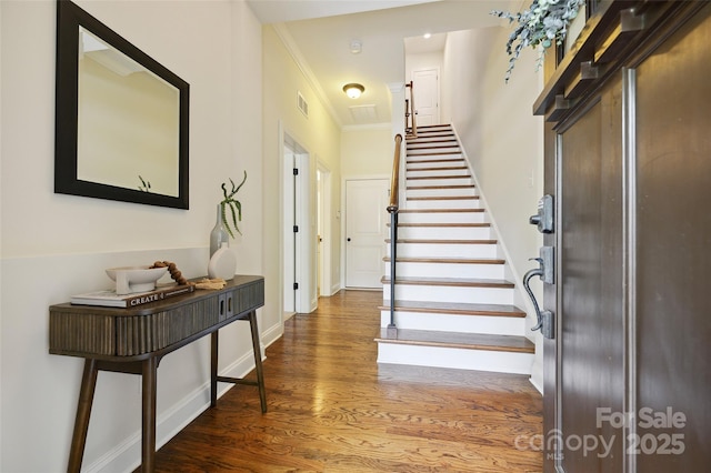 foyer entrance with stairway, wood finished floors, crown molding, and baseboards