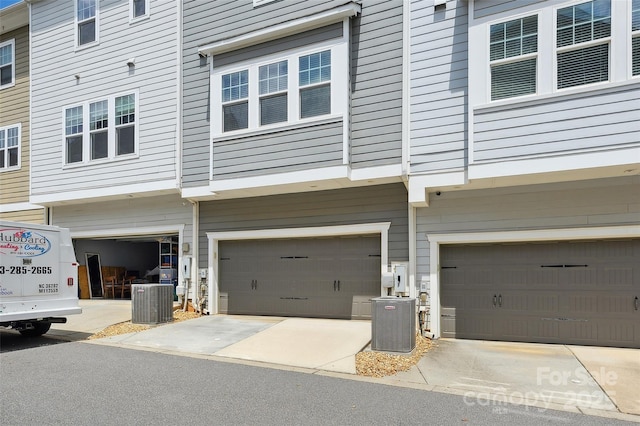 view of side of home with central air condition unit and an attached garage