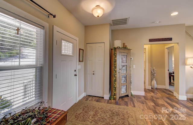 entryway featuring visible vents, wood finished floors, and baseboards