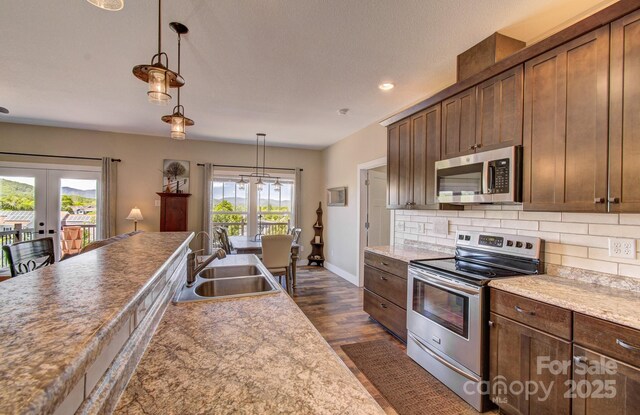 kitchen with plenty of natural light, stainless steel appliances, french doors, and a sink