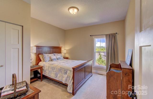bedroom with light colored carpet, a textured ceiling, baseboards, and visible vents