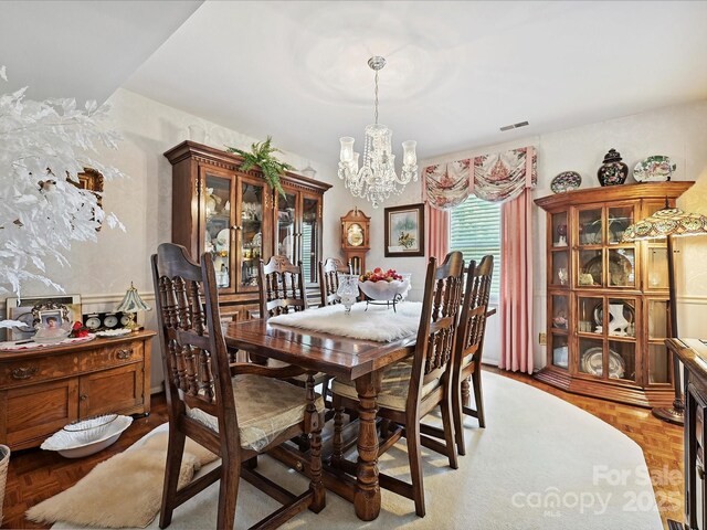 dining area featuring an inviting chandelier and visible vents