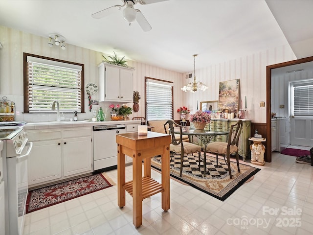 kitchen with tile countertops, wallpapered walls, dishwasher, stove, and a sink