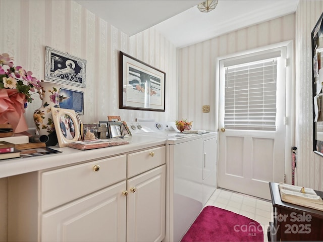 laundry area featuring light tile patterned flooring, cabinet space, wallpapered walls, and washer and dryer