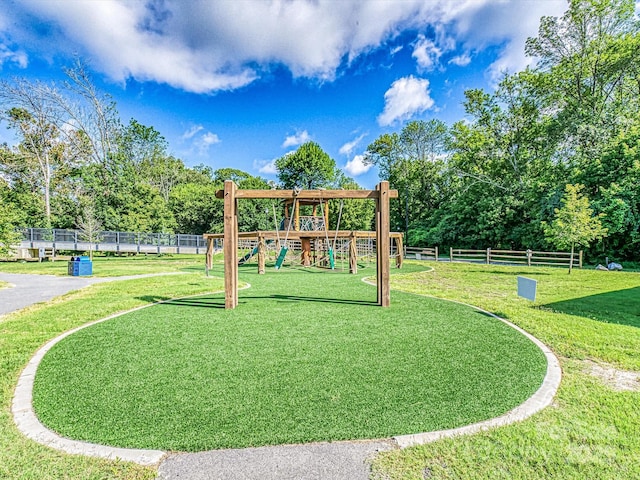 community jungle gym featuring a yard and fence