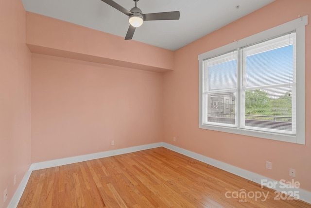 empty room featuring baseboards, light wood-style flooring, and a ceiling fan