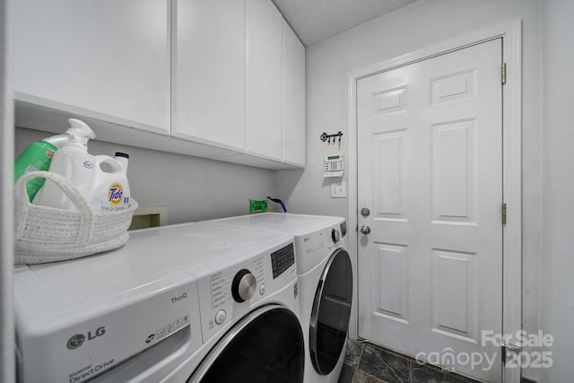 laundry room featuring washer and clothes dryer, cabinet space, and dark marble finish floors