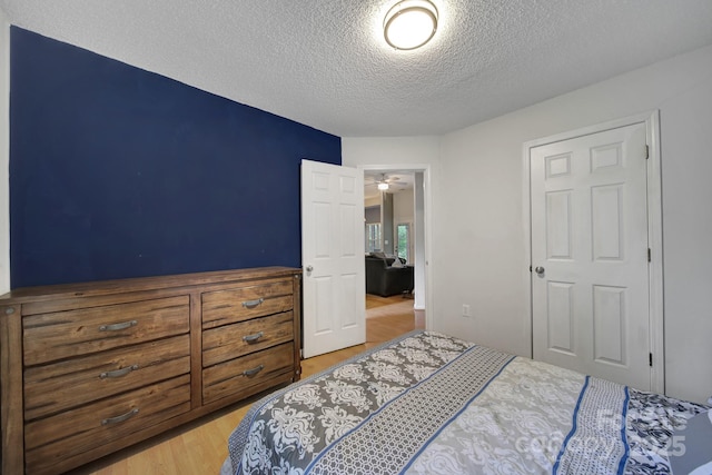 bedroom with a textured ceiling and wood finished floors