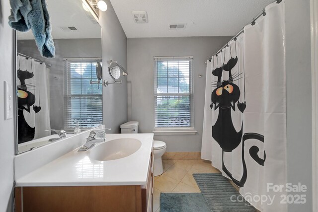 full bathroom featuring vanity, toilet, healthy amount of natural light, and tile patterned floors