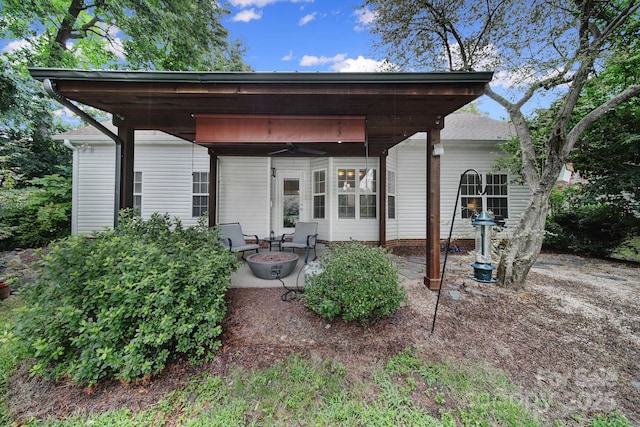 rear view of house with a fire pit and a patio area