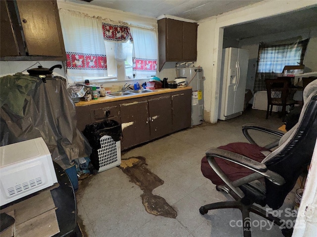 302 Melrose Dr SW, Concord, NC 28025 - kitchen with dark brown cabinetry, light floors, a sink, water heater, and white fridge with ice dispenser
