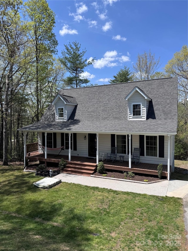 view of front of property with a shingled roof, a front lawn, and covered porch