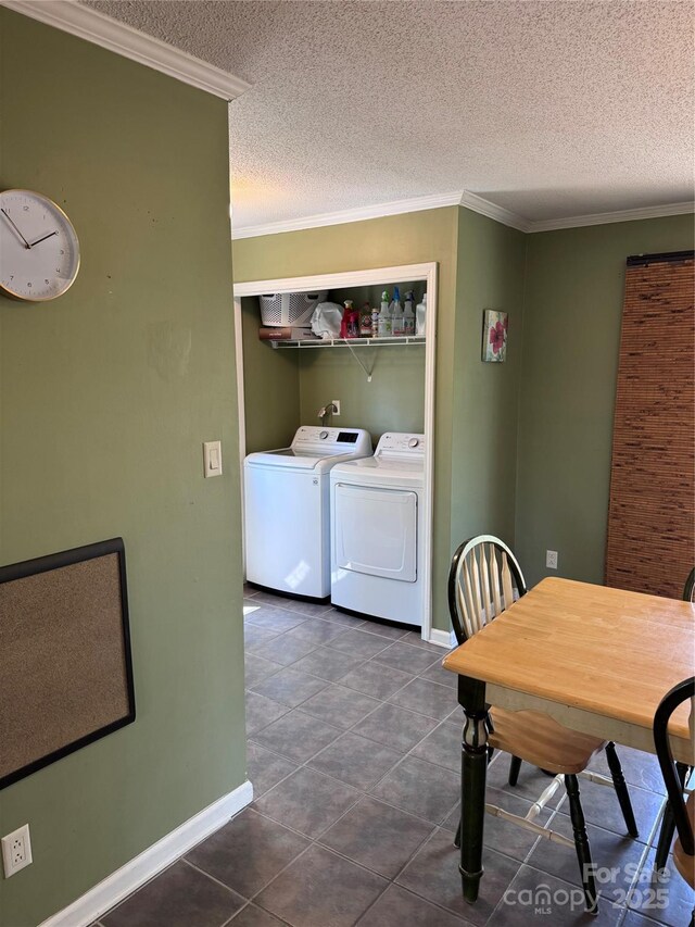 dining room featuring separate washer and dryer, baseboards, ornamental molding, and a textured ceiling