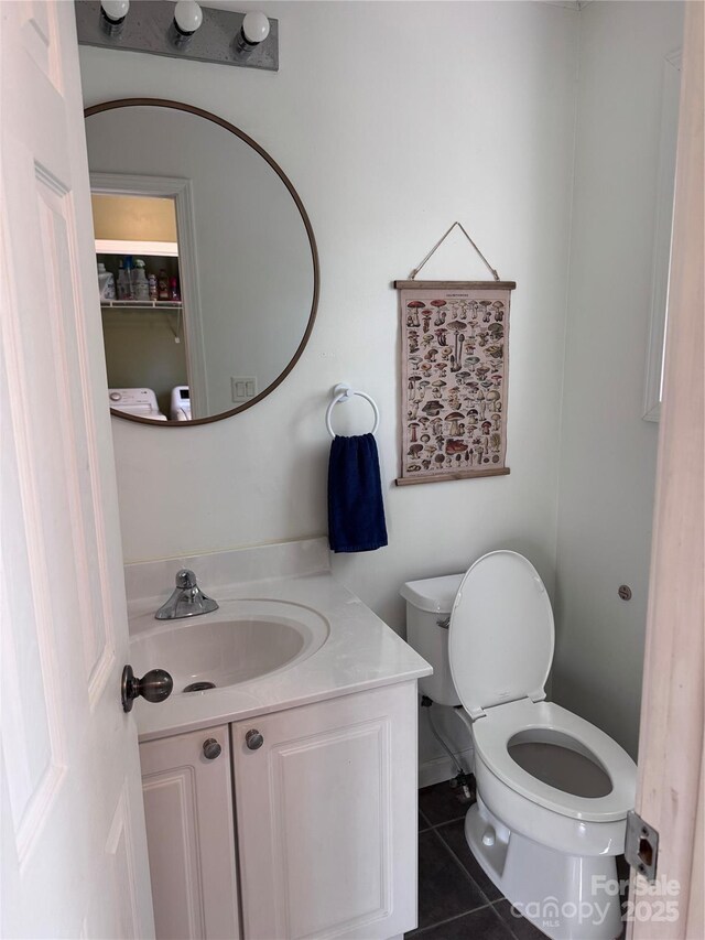 half bath featuring toilet, tile patterned flooring, and vanity