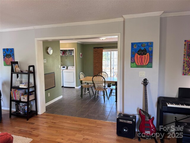 interior space with crown molding, separate washer and dryer, baseboards, and dark wood finished floors