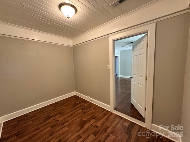 unfurnished room featuring crown molding, baseboards, visible vents, and dark wood-type flooring