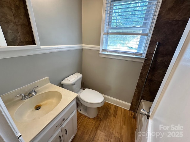 bathroom with vanity, walk in shower, toilet, and wood finished floors