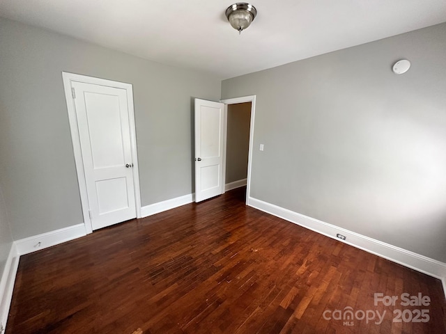 unfurnished bedroom featuring baseboards and wood finished floors