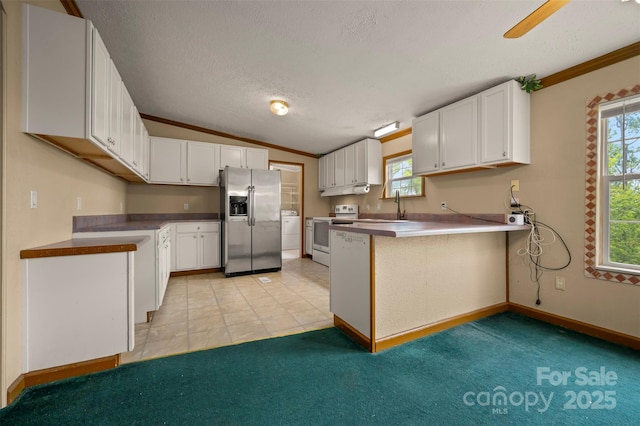 257 River Crest Dr, Flat Rock, NC 28731 - kitchen featuring electric range oven, white cabinetry, a peninsula, stainless steel fridge, and crown molding