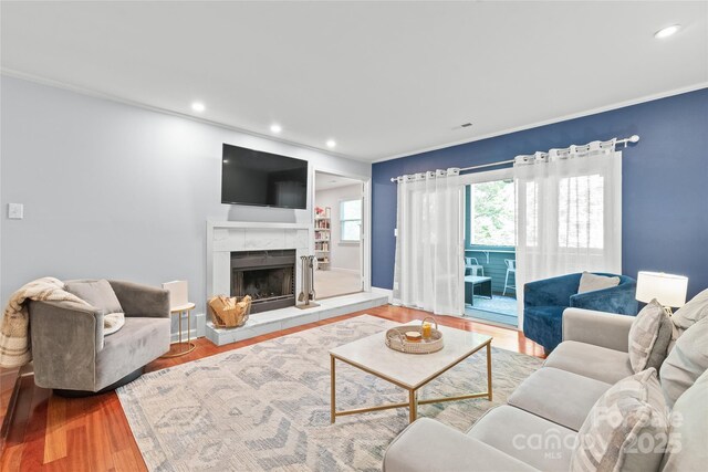 living room with a fireplace, recessed lighting, and wood finished floors