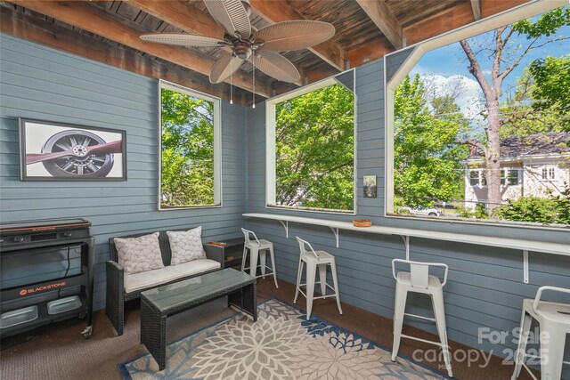 sunroom / solarium featuring a healthy amount of sunlight, outdoor lounge area, and a ceiling fan
