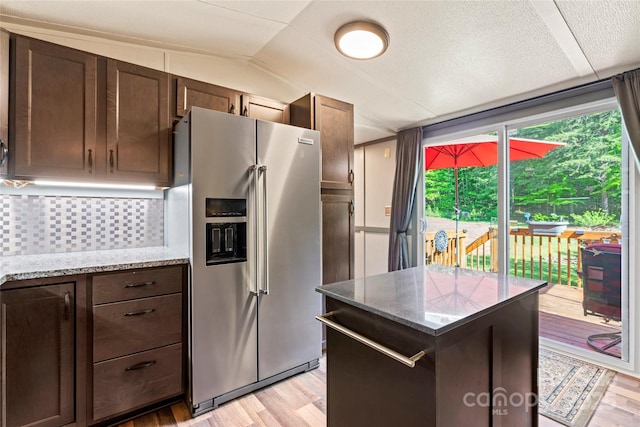 743 Dream Ln, Salisbury, NC 28146 - kitchen with dark brown cabinets, stainless steel fridge, a center island, light wood-type flooring, and backsplash