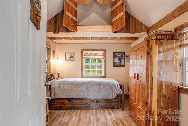 bedroom with vaulted ceiling and wood finished floors