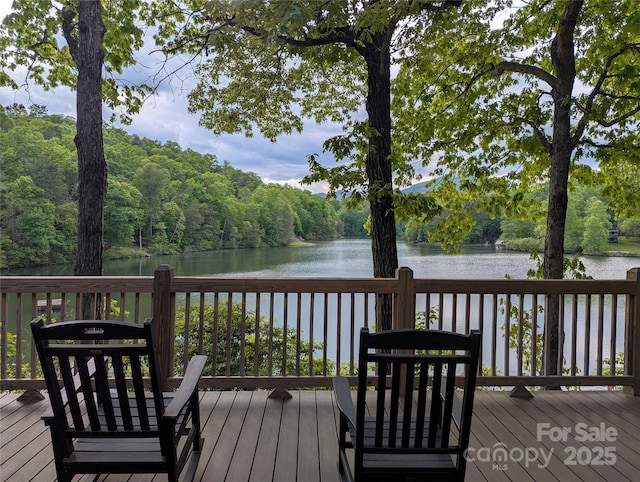 wooden terrace featuring a water view and a view of trees