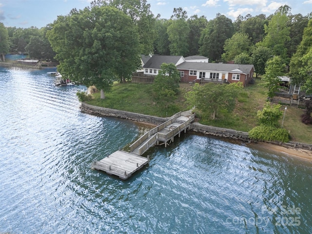 exterior space featuring a water view, a view of trees, and a yard