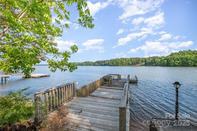 dock area featuring a water view and a wooded view