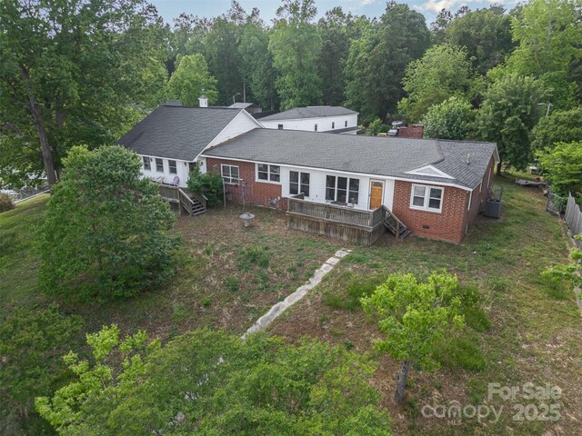 view of front of home featuring brick siding, fence, a chimney, and a deck