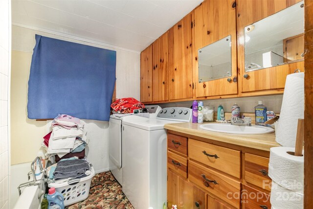 clothes washing area with a sink, cabinet space, and washing machine and dryer