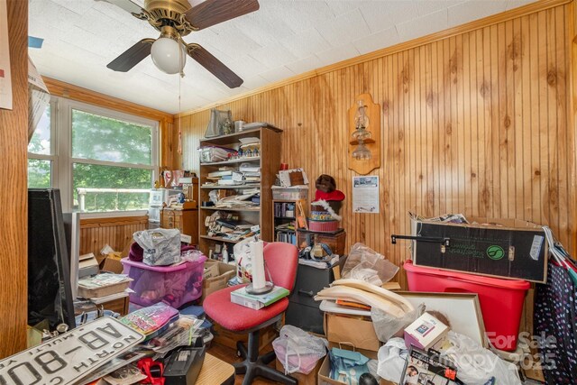 misc room featuring ceiling fan and wooden walls
