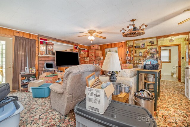 living room with ceiling fan and wooden walls