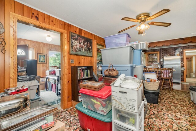 miscellaneous room featuring ornamental molding, a ceiling fan, and wood walls