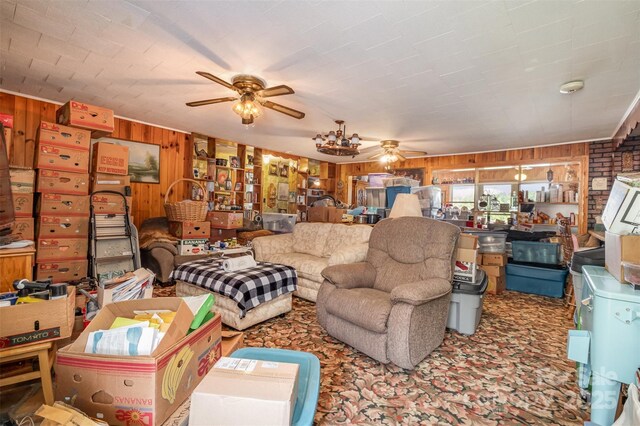living area featuring a ceiling fan, carpet, and wood walls
