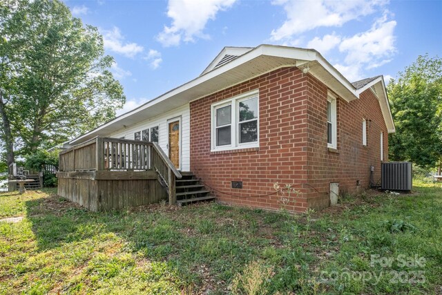 back of house featuring brick siding, central AC unit, a wooden deck, and crawl space
