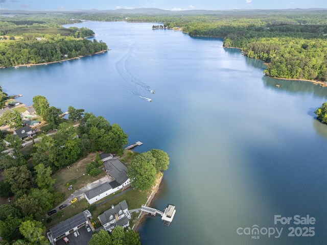 birds eye view of property with a water view and a view of trees