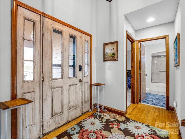 foyer with baseboards and light wood finished floors