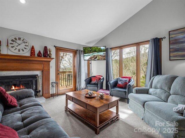 carpeted living room featuring recessed lighting, high vaulted ceiling, and a lit fireplace